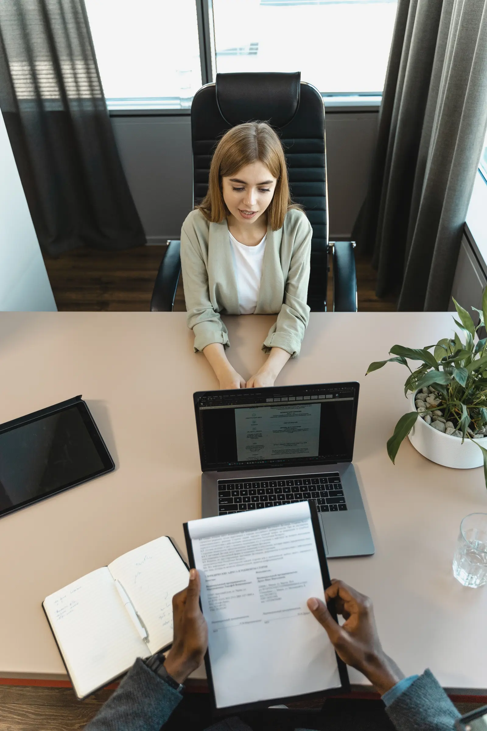 An interviewer reviewing a candidate's CV across a desk